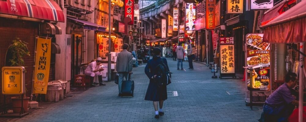 A solo female traveler walking through Kyoto’s iconic red torii gates