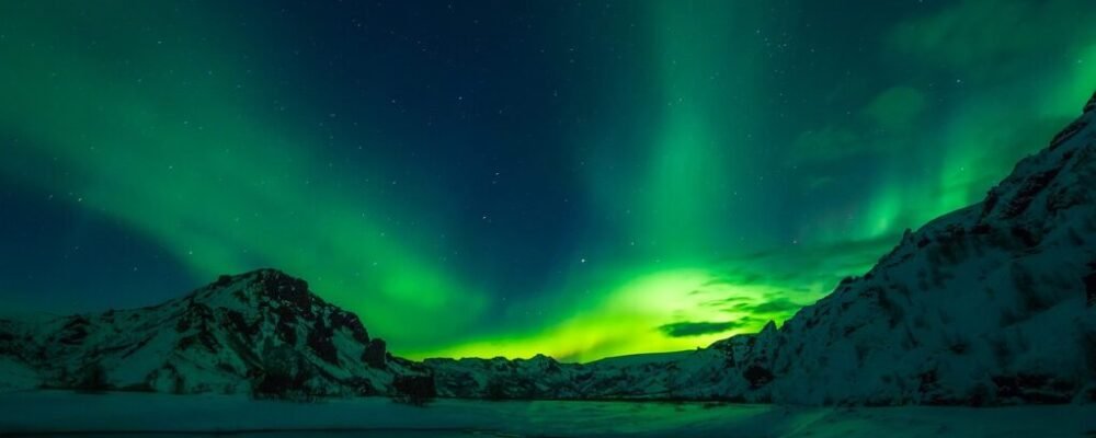 Solo female traveler hiking in Iceland, surrounded by waterfalls and mountains